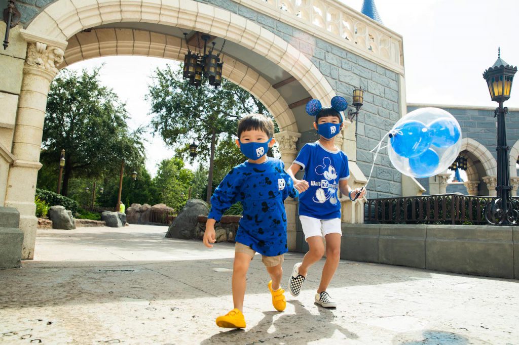 Kids in the new Wishes Come True Blue Mickey Mouse Ear headband, mask, spirit jersey and shirt with Walt Disney World Resort logo