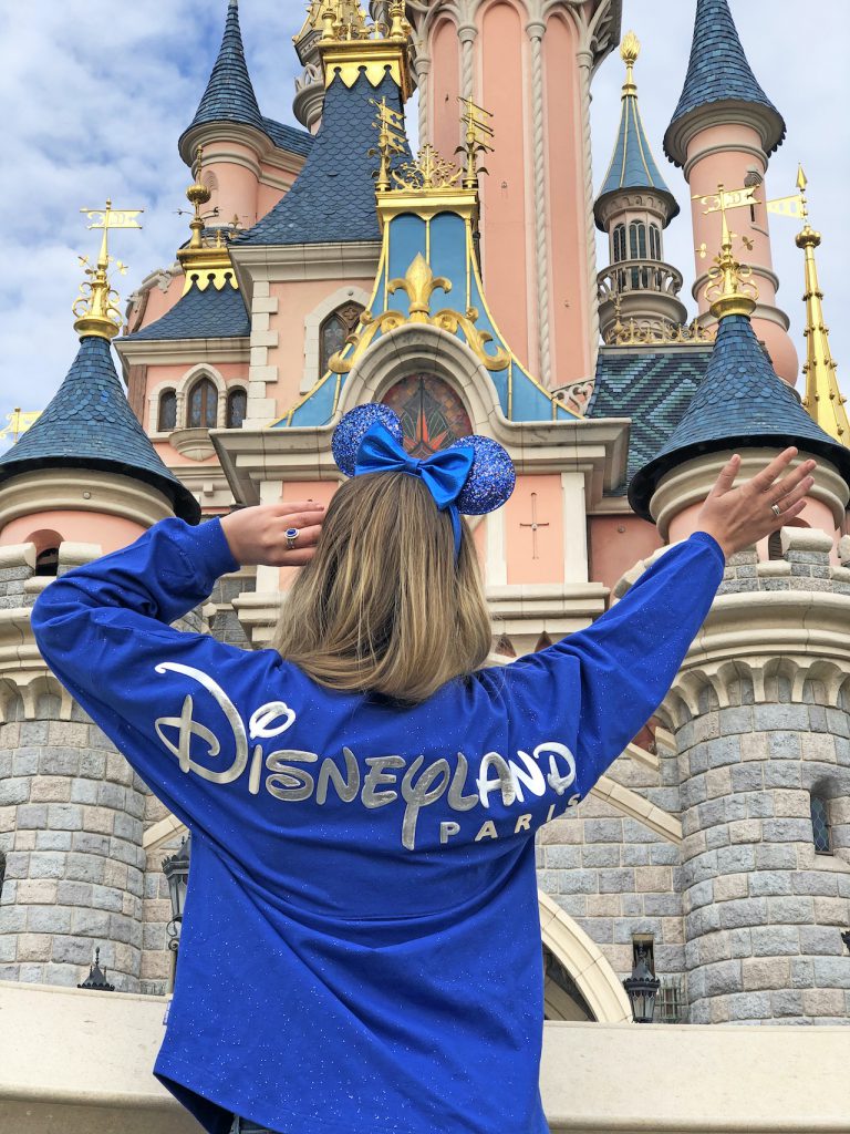 Girl in Wishes Come True Blue Minnie Mouse Ear headband and spirit jersey with Disneyland Paris logo